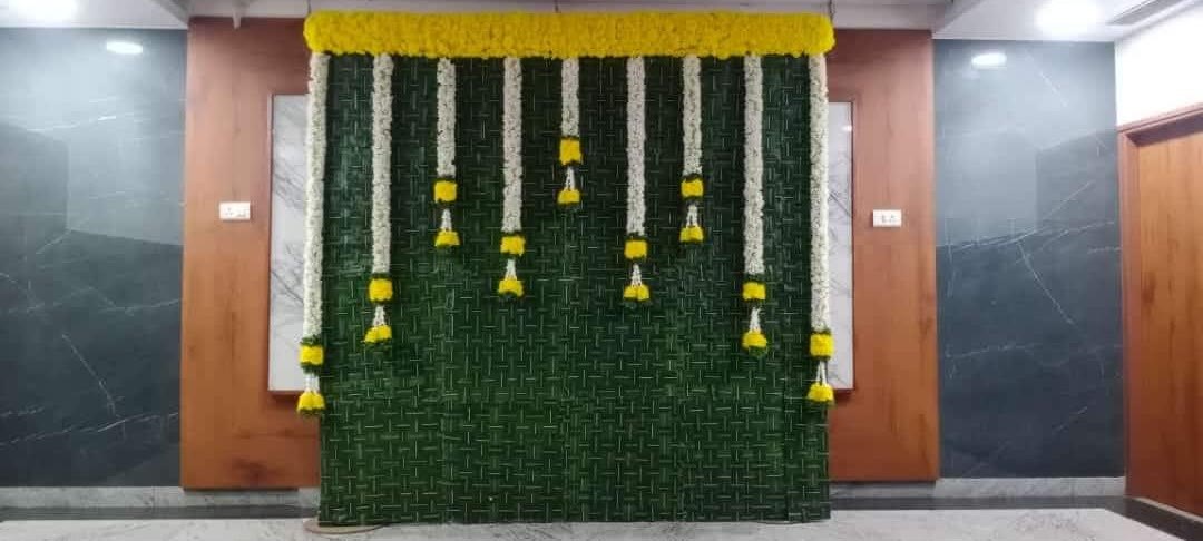 Green mat backdrop with jasmine and marigold hangings