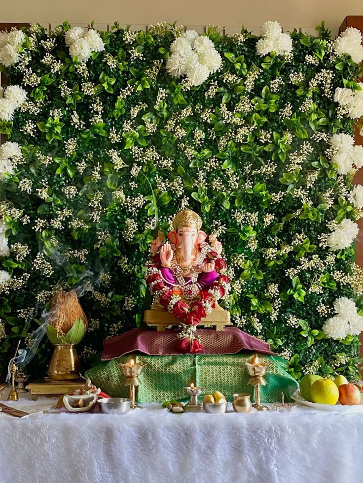 SF-52 — Ganesha pooja decoration with green leaf wall and white flower backdrop