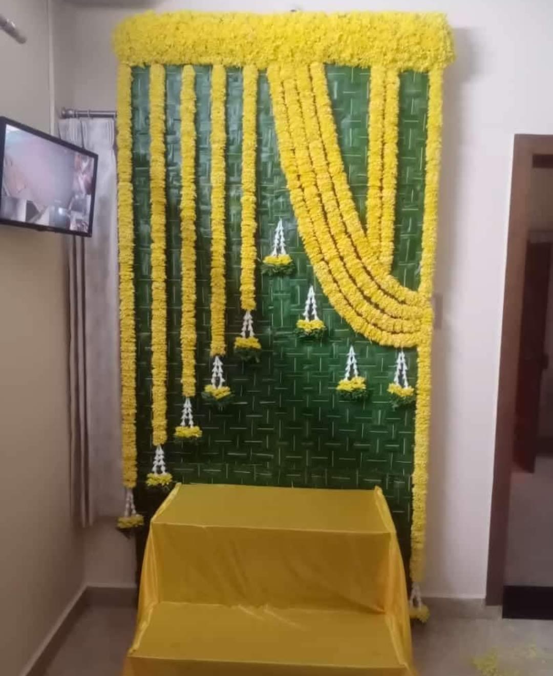Marigold and green mat floral backdrop for home function